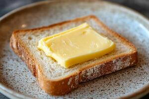 Fresh butter placed on a slice of rustic bread photo