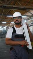 Indian worker walks with a window frame in a window factory video