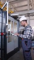 Engineer entering data in CNC machine at pvc window factory to get the production going video