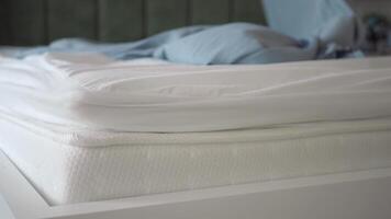 Close-up of a white mattress with white sheet and light gray bedding video