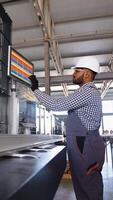 Indian engineer working at programmable CNC machine in factory industries video