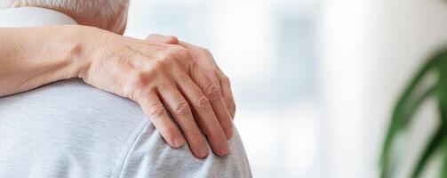Caregiving elderly compassion concept. Supportive hand on shoulder of an elderly person. photo