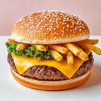 Juicy cheeseburger with fries and lettuce in a sesame seed bun. photo