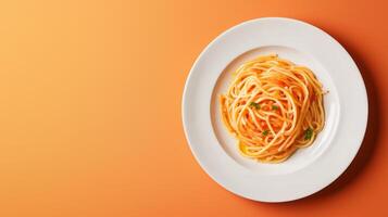 Plate of spaghetti on a vibrant orange background. photo
