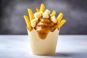 Delicious poutine with fries, cheese curds, and gravy in a cup. photo