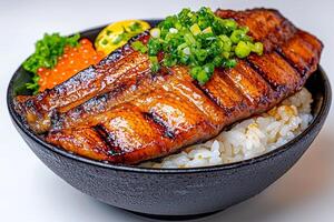 Grilled fish served over rice with garnishes in a bowl. photo