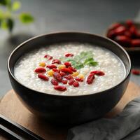 Focus on senior health concept. Bowl of rice porridge topped with goji berries and herbs photo