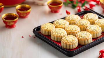Chinese new year joyous reunion concept. Mooncakes arranged on a tray with tea cups nearby. photo