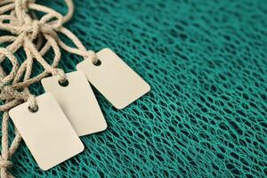 Ocean preservation action concept. Blank tags on textured teal fabric background photo