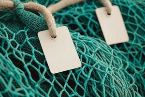 Ocean preservation action concept. Close-up of a teal fishing net with blank tags attached. photo