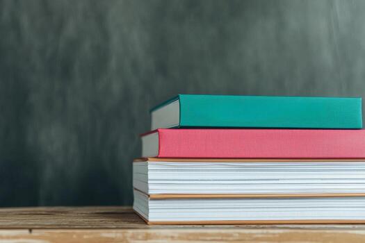 Employee with incentive concept. Stack of colorful books on a wooden surface against a textured background. photo