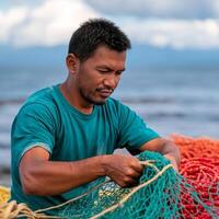 Sustainable management with fisher. A man repairs fishing nets by the sea. photo