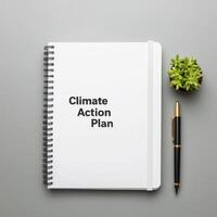 Plan for climate action concept. Climate action plan notebook with a pen and a small plant. photo