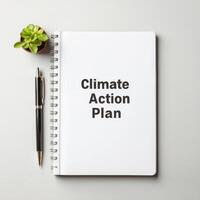 Plan for climate action concept. Notebook with Climate Action Plan text and a plant on a table. photo