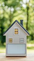 Efficient tech of investment and energy concept. Model house on a table with greenery in the background. photo