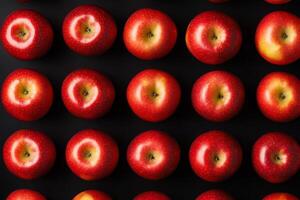 Red apples arranged neatly on a dark surface. photo