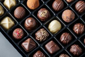 Luxurious chocolate truffles. Assorted gourmet chocolates in a box, showcasing various designs and textures. photo