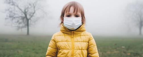 Lung damage causes concept. Child in a mask stands in a foggy field wearing a yellow jacket. photo