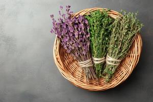 Herbs tied and dried. Dried herbs arranged in a woven basket on a textured surface. photo