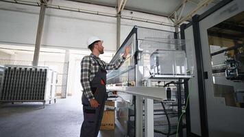 Engineer working at programmable CNC machine in window factory video