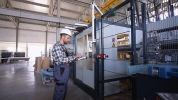 Engineer entering data in CNC machine at pvc window factory to get the production going video