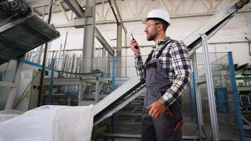 förman ger kommandon till arbetare använder sig av walkie prat på fönster fabrik transportband video