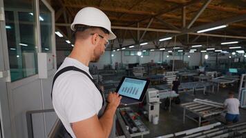 fönster fabrik förman är använder sig av en bärbar dator med ett teknik programvara på produktion linje video