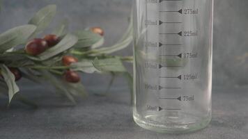 Carefully measuring oil using a transparent glass jug along with a scale video