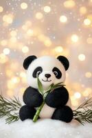 Miniature black-and-white panda holding bamboo on a soft snow patch with pastel lighting in a cozy atmosphere photo
