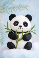 Felted miniature black-and-white panda holding bamboo on soft snow patch with pastel lighting photo