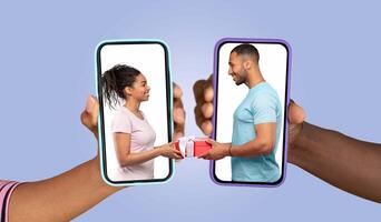 A couple engages in a loving exchange of a gift using their smartphones. They smile at each other, highlighting their connection and joy as they communicate through an app. photo