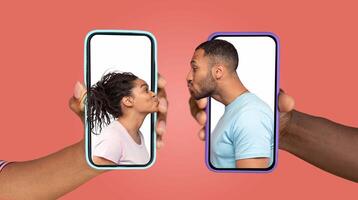 Two people express love and connection while using smartphones. Handheld devices show their faces, emphasizing their online communication and affection in a contemporary relationship. photo