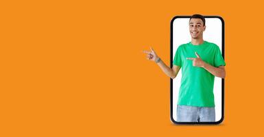 A smiling individual stands in front of a large smartphone screen, gesturing with hands to suggest communication. The background features a vibrant color, enhancing the tech-savvy vibe. photo