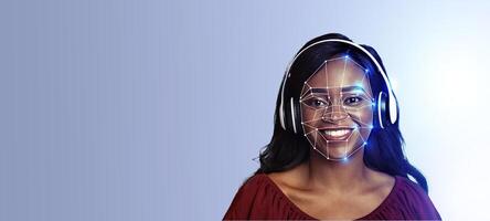 A woman smiles while wearing headphones, showcasing facial recognition technology. The background is isolated with empty space, emphasizing the futuristic identification features. photo