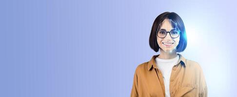 A young woman with glasses smiles confidently while showcasing modern facial recognition technology. The background is a soft blue gradient, emphasizing her expression and the tech interface. photo