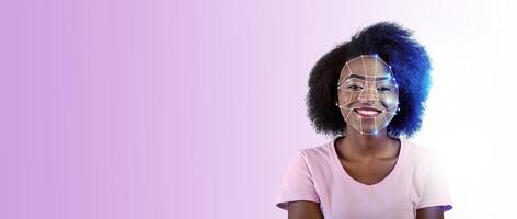 A smiling individual with unique features is depicted with a facial recognition overlay. The background is colored with a gradient, highlighting the advanced technology used for identification. photo