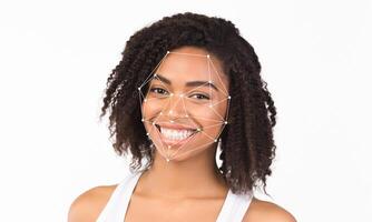 A woman smiles while facial recognition technology analyzes her features. The system outlines key facial points for identification purposes against a clean white background. photo