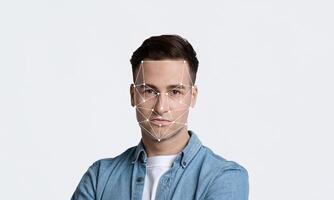 The model stands against a minimalist background, showcasing facial recognition technology. Geometric lines map the face, illustrating active identification and data analysis. photo