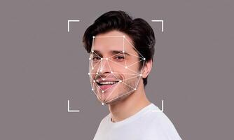 A young man smiles while facial recognition technology analyzes his features. The digital overlay highlights key facial points for identification. photo