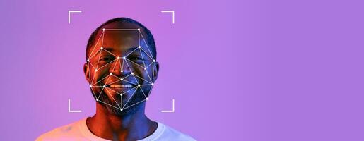 A smiling person is featured against a vibrant purple background with facial recognition technology overlayed on their face. The image focuses on the identification process. photo
