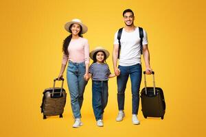 Happy Arab Family Of Three Holding Hands And Walking With Suitcases On Yellow Studio Background, Cheerful Middle Eastern Parents With Little Daughter Ready For Vacation Trip, Full Length Shot photo