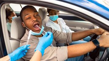 African American Family Getting Tested For Covid-19 Sitting In Car, Wearing Protective Face Masks. Drive-Thru Covid Testing Site Concept. Coronavirus Diagnostic, Pandemic Outbreak photo