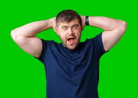 A surprised man expresses shock against a bright green background photo