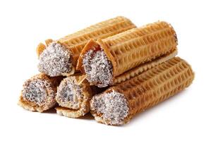 Delicious rolled wafers filled with chocolate cream and coated in coconut flakes on a white background photo