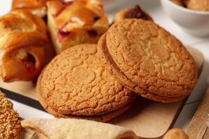 Freshly baked cookies surrounded by assorted pastries and baked goods in a cozy setting photo