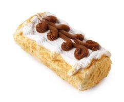 Delicious dessert with layers of cake, cream, and chocolate frosting topped with decorative swirls photo