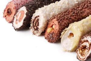 Delicious dessert rolls filled with cream and coated in chocolate and nuts, ideal for any celebration or gathering photo