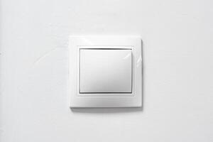 White light switch on a plain wall, designed for easy access and modern aesthetics in home interiors photo