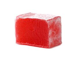 Red jelly cube sits on a white background showcasing its translucent texture and vibrant color photo