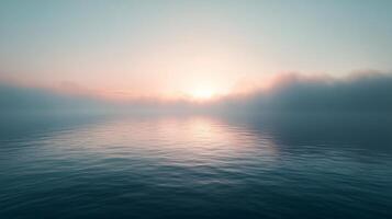 Soft light of sunrise reflecting on calm water with low hanging fog creating a serene and peaceful atmosphere photo